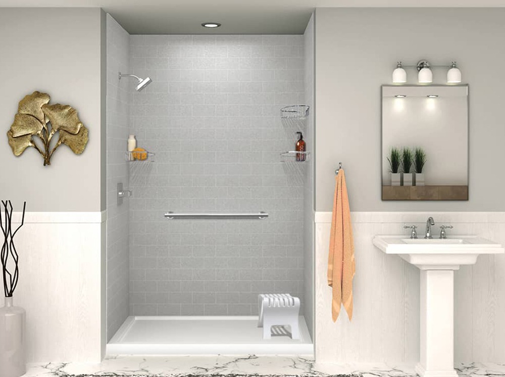 Modern bathroom featuring a gray tiled shower, a decorative wall piece, a sink with a mirror, and a towel rack with an orange towel.